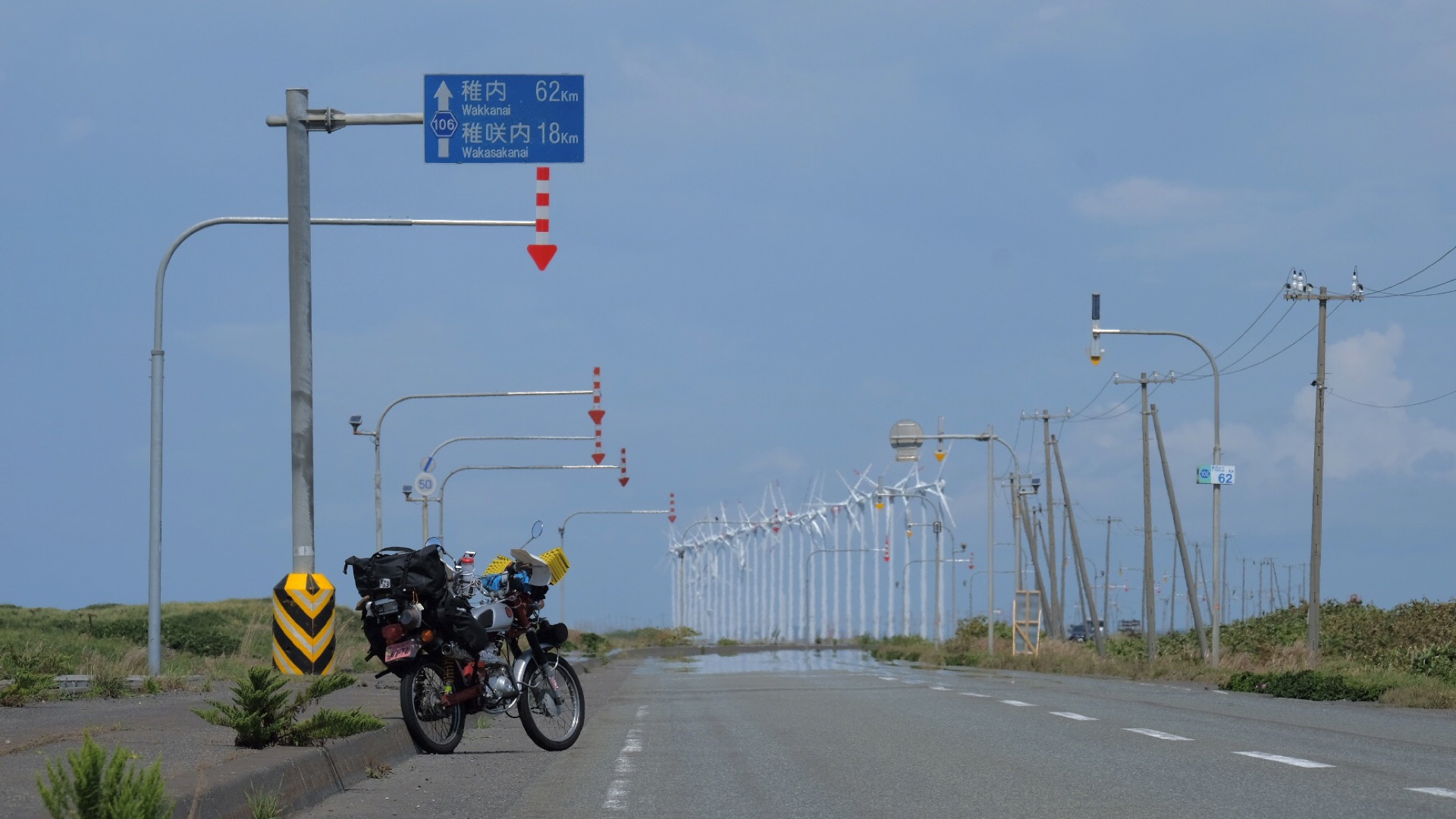 風車が並ぶ道と稚内方面の標識